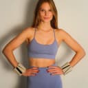  Vrouw doet staande Pilates oefening met beige polsgewichten thumbnail