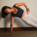 Vrouw in zijplank oefening met beige polsgewichten voor extra weerstand thumbnail